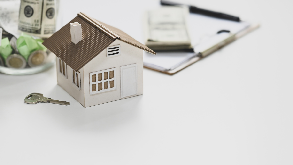 Mini House Model and Key Composition on White Background